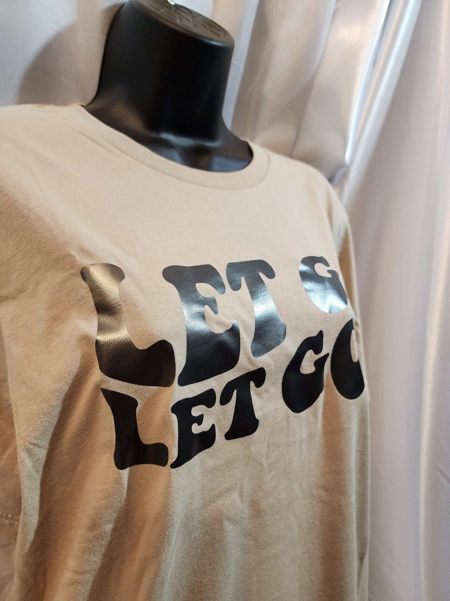 Let go let God, tan color t-shirt.